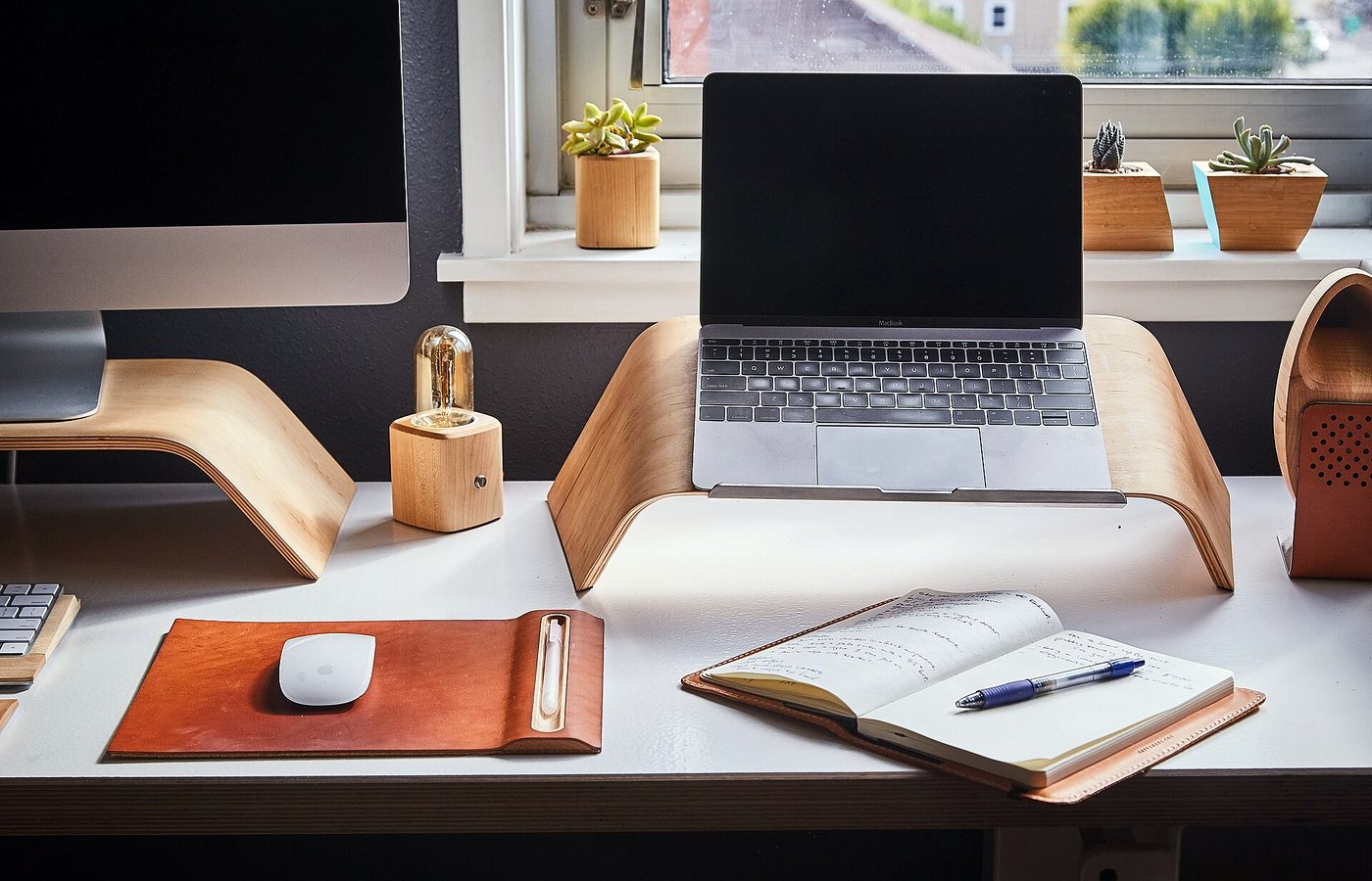 Bureau clair avec un ordinateur portable, un carnet ouvert et une lampe